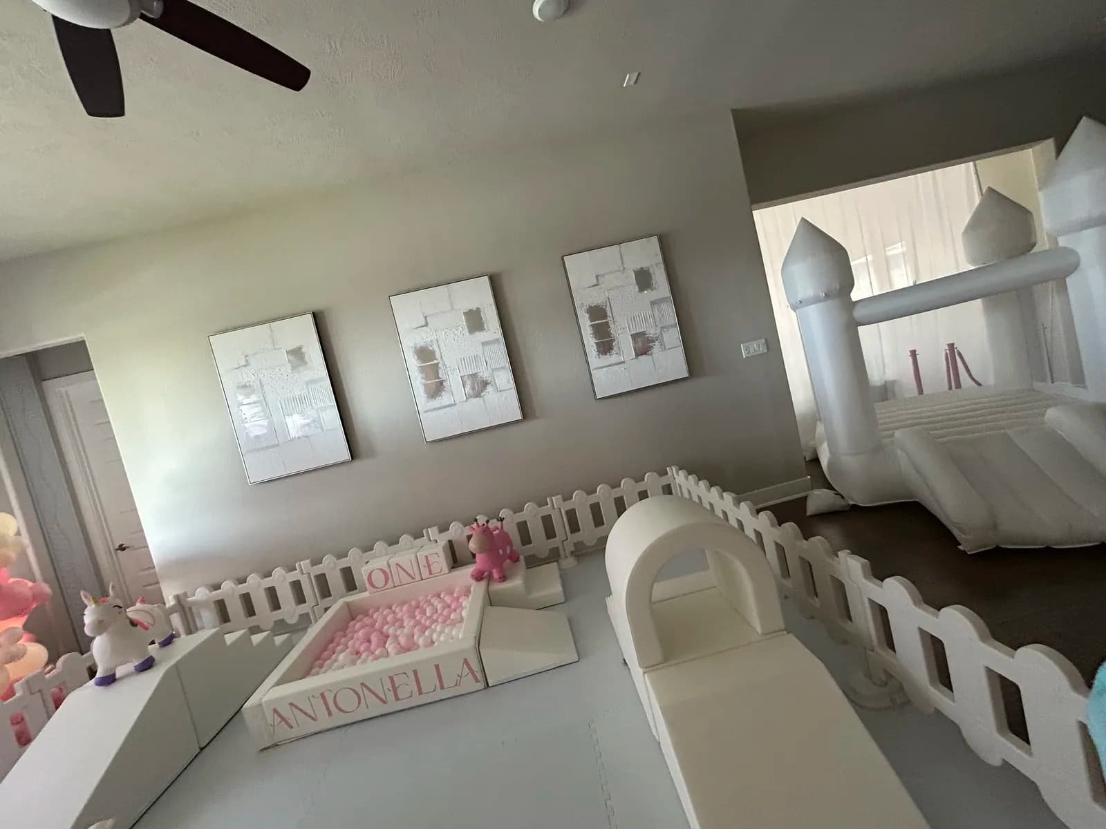 White bounce house and soft play party setup together indoors