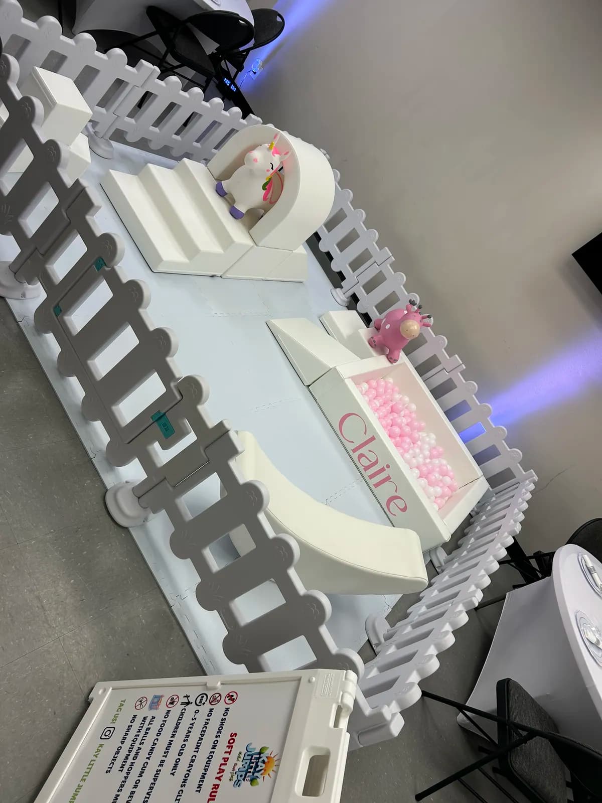 Personalized soft play with slide and bunny rockers under party lighting