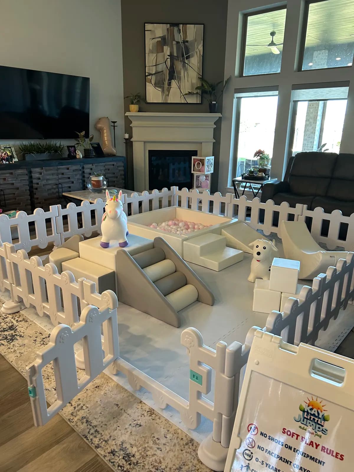 Neutral soft play with climbers, slide, and giraffe rocker in a family living room